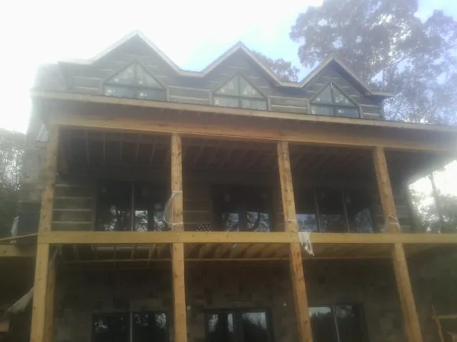Dormers and porch framing on a large log home under construction — Roof Coating work by our crew in Monrovia