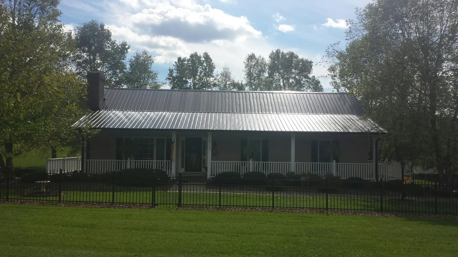 Gray metal roof on a brick ranch with a full width front porch — Gutter Guard Installation work by our crew in Monrovia